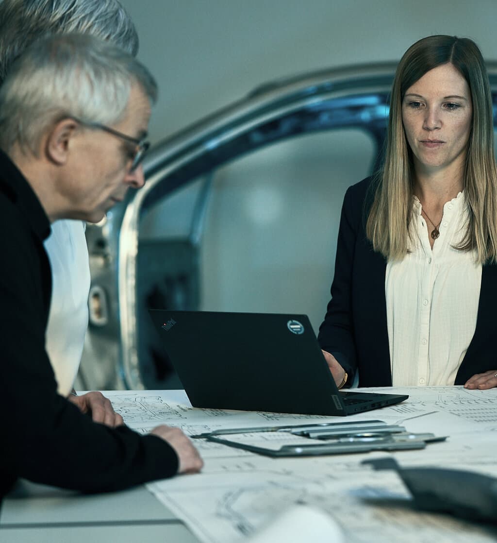 Zwei Mitarbeitende von GEDIA sitzen an einem Tisch und besprechen Unterlagen, die vor ihnen liegen